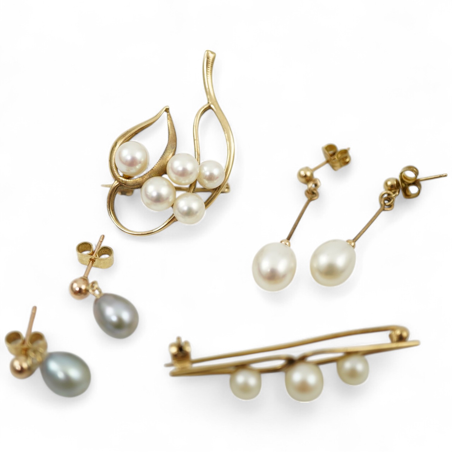A group of cultured pearl jewels, comprising: two pairs of cultured pearl drop earrings, longest 3cm, mounted in gold; and two cultured pearl brooches mounted in 9ct gold, longest 4.1cm, British hallmarks, combined gross